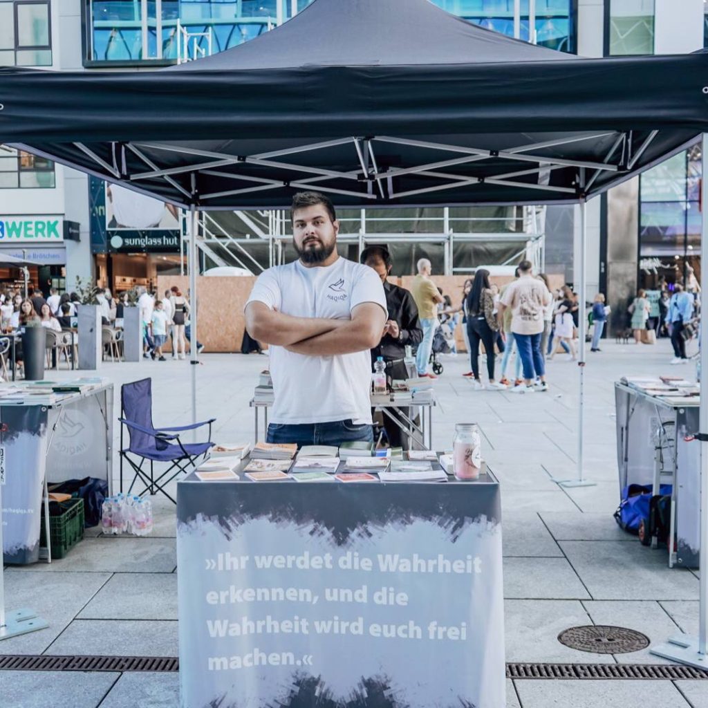 Menschen am Stand mit Flyern und Bibeln